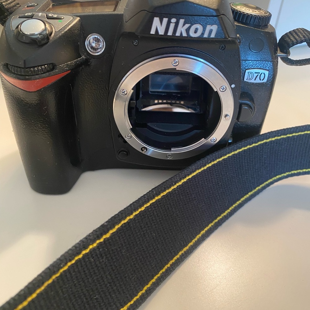 Nikon D70 SLR camera body with instruction book and charging cord w/ battery.